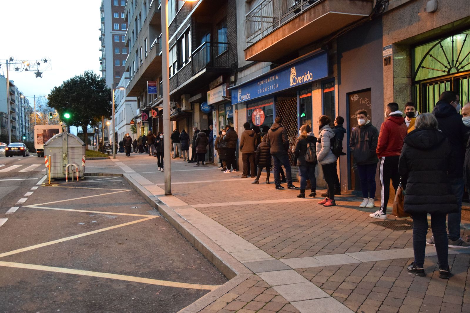 Varias personas hacen cola en la avenida de Portugal.