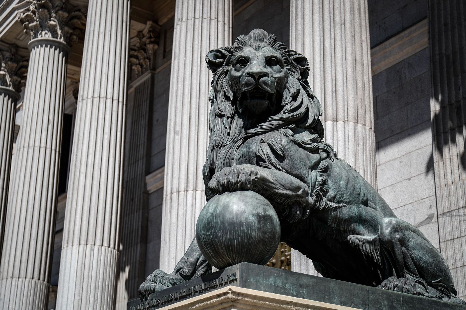 Uno de los emblemáticos leones que se encuentran delante de la fachada del Congreso de los Diputados en la Plaza de las Cortes de Madrid.
