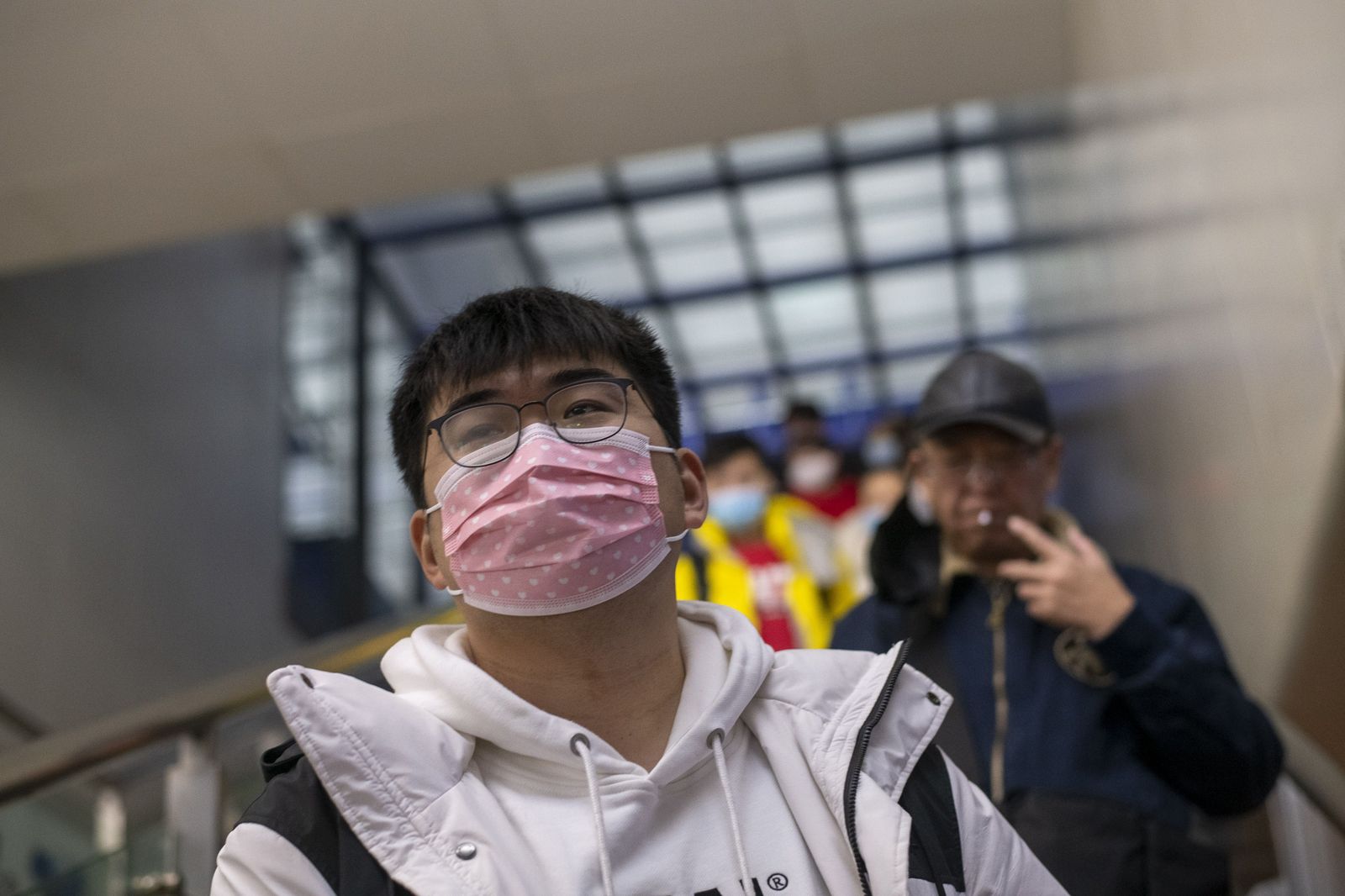January 27, 2019 - Shanghai, China: A young man wears face masks in wake of the coronavirus outbreak as he rides an escalator to the platform from which a high speed train to Nanning, Guangxi Province