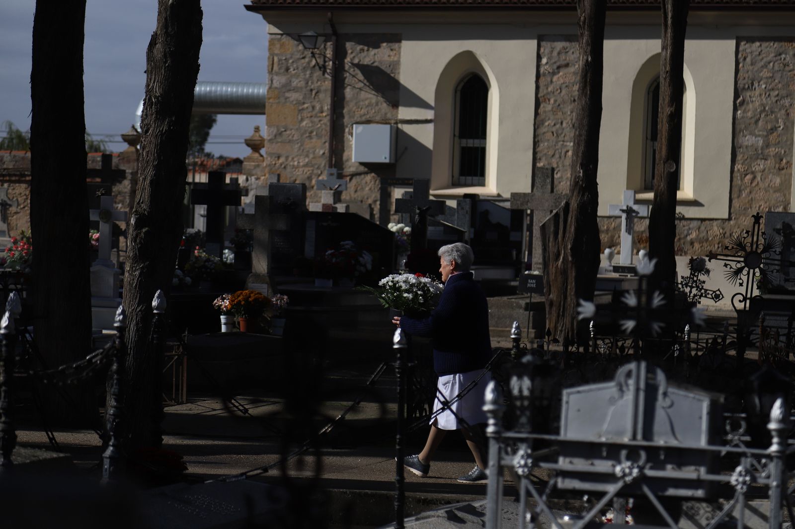 Una mujer porta un centro de flores en el Cementerio de San Atilano Foto: María Lorenzo