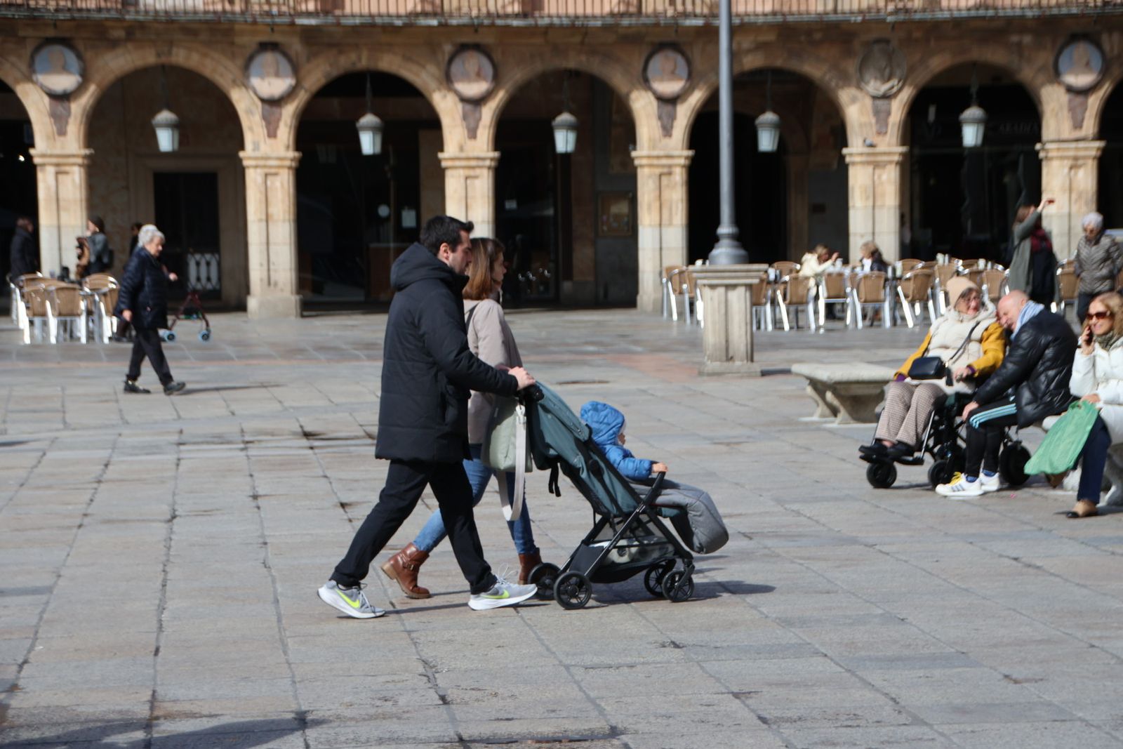 Pareja con carrito de bebé paseando por la Plaza Mayor