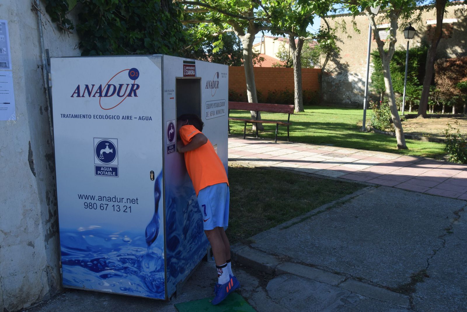 Un niño bebe agua de la potabilizadora portátil
