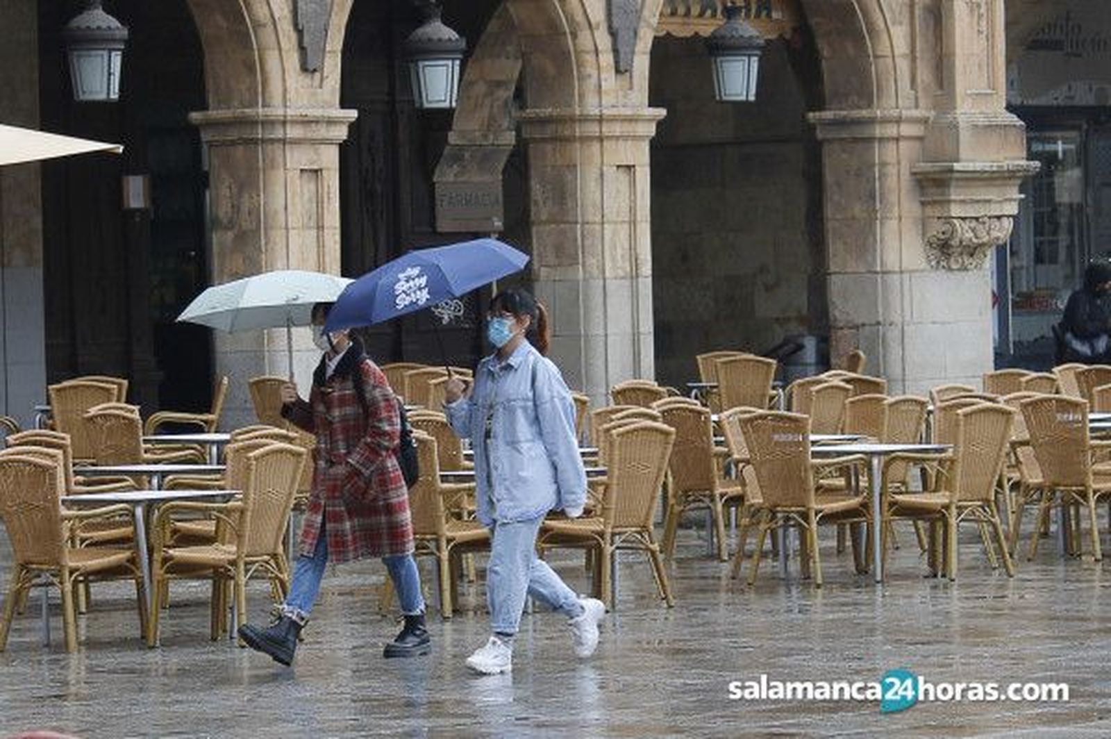 Dos chicas jóvenes pasean por la Plaza Mayor en una jornada de lluvia. | S24H