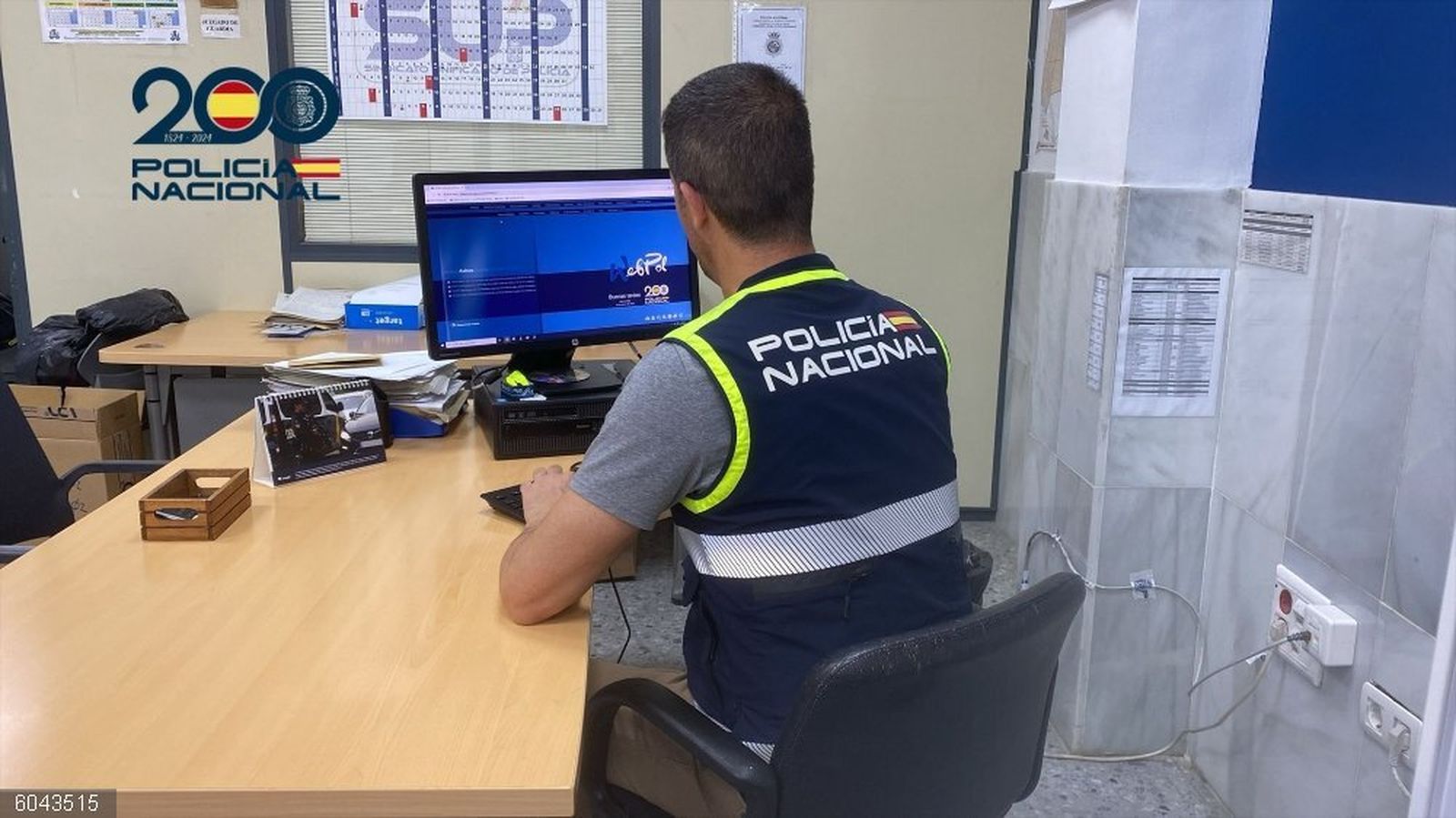 Agente de la Policía Nacional en una oficina, con un ordenador