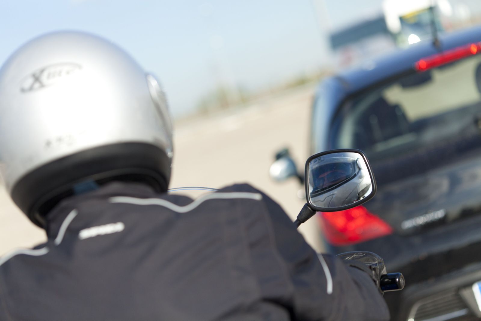 Un motorista detrás de un coche. Foto @DGTes
