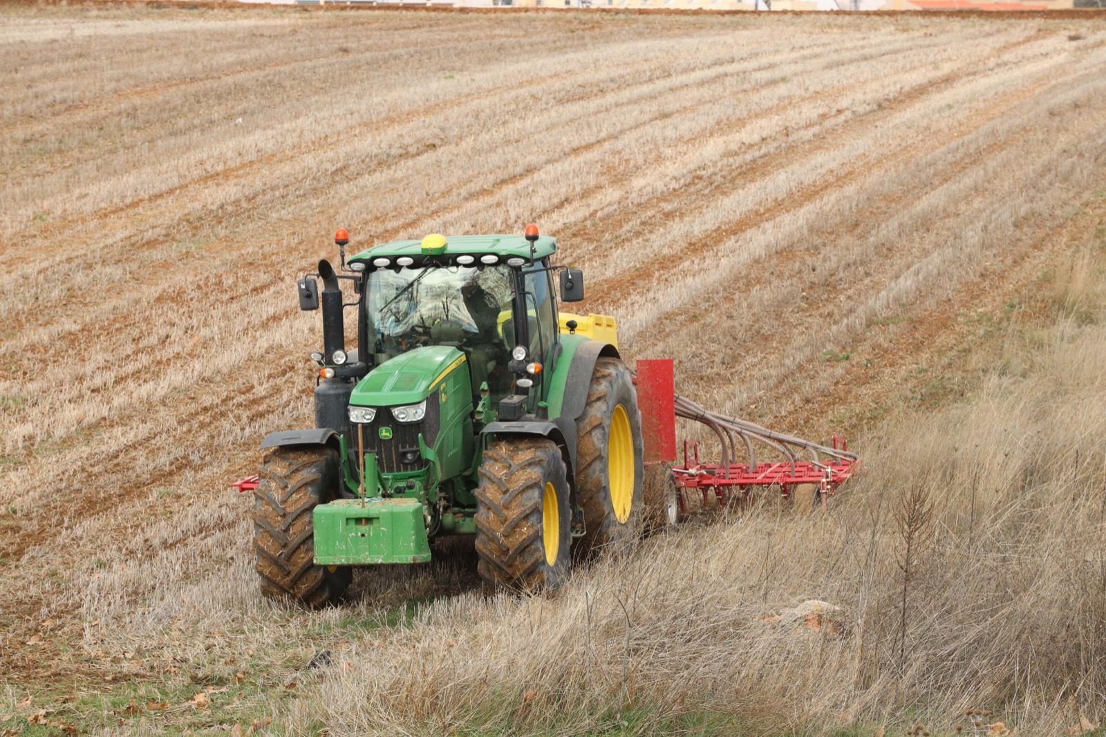 Un tractor ara una tierra de cultivo | Foto de archivo