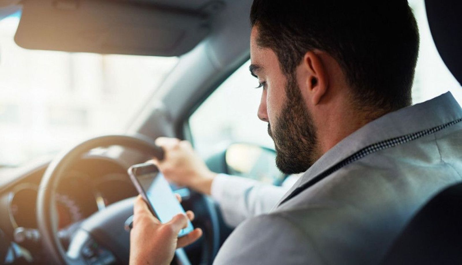 Un conductor con el móvil al volante. Archivo