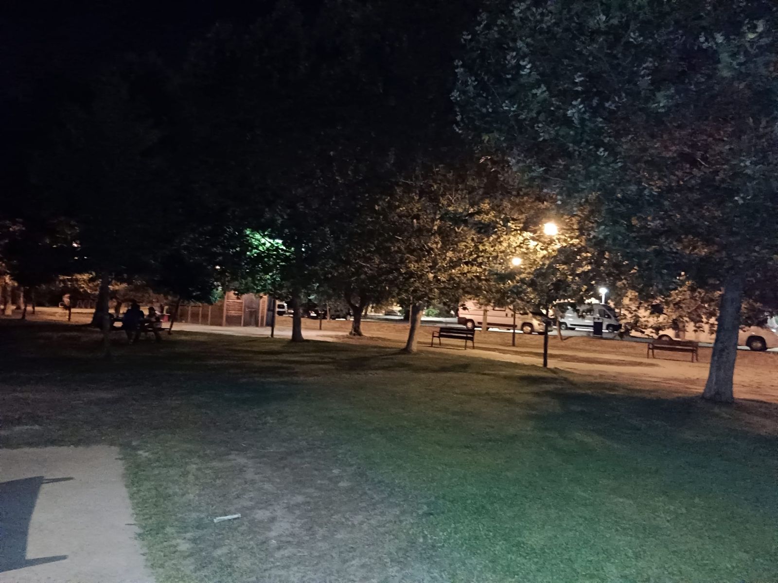 Un grupo de personas sentados en una de las mesas a oscuras.