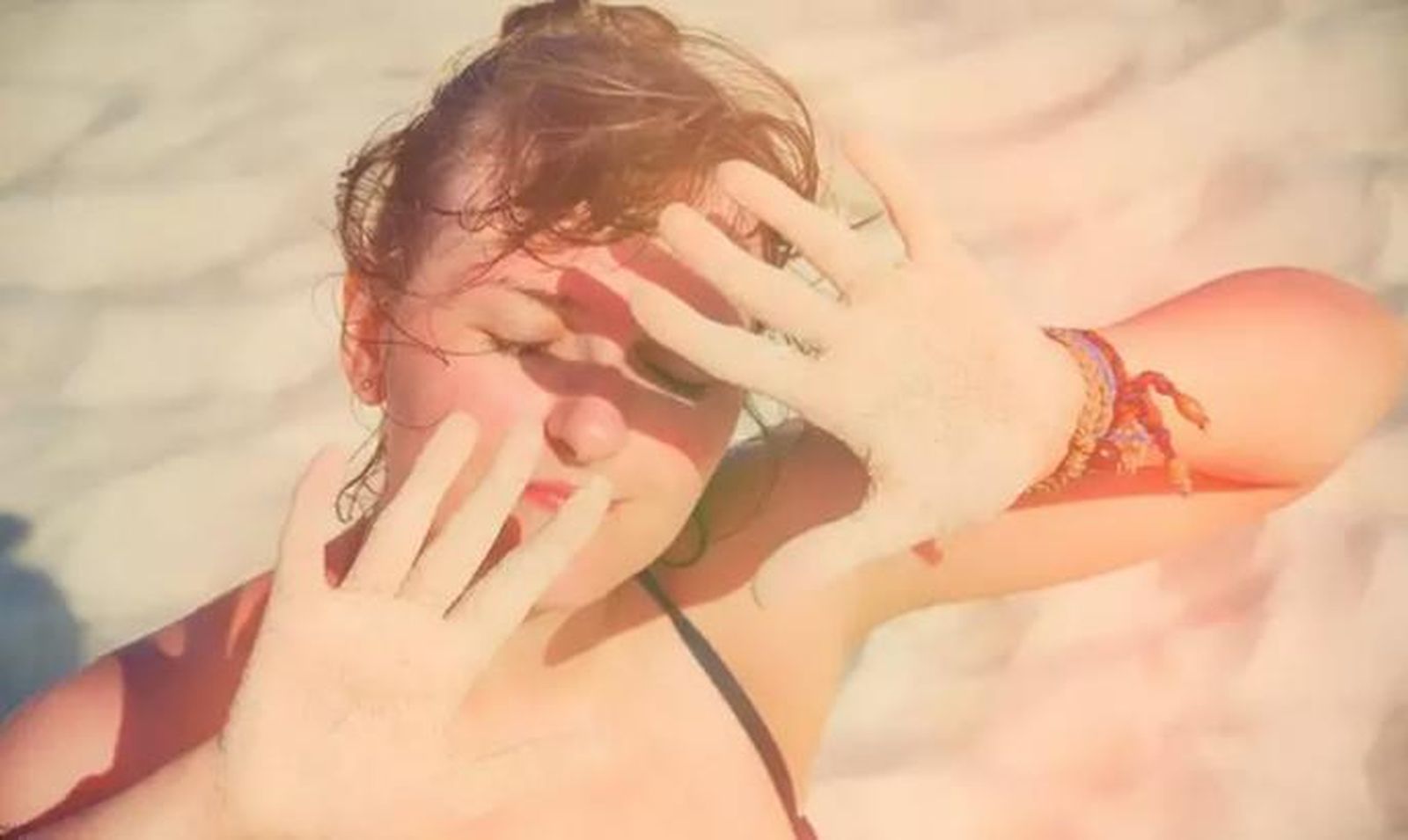 Archivo - Imagen de archivo de una mujer protegiéndose del sol en la playa. - ANDREY ZHURAVLEV/ISTOCK - Archivo
