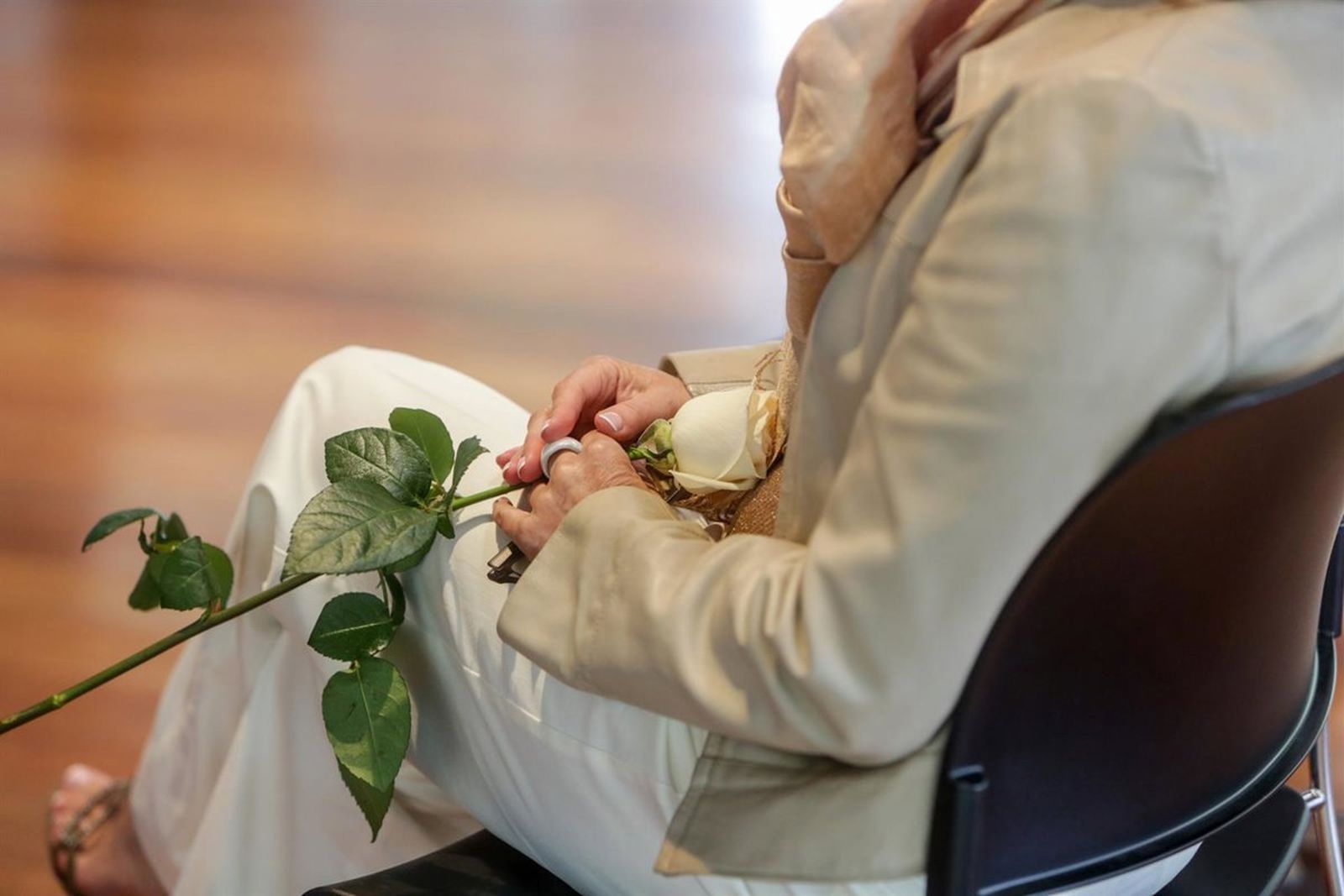 Detalle de una contrayentes sujetando una rosa blanca durante la celebración de su boda