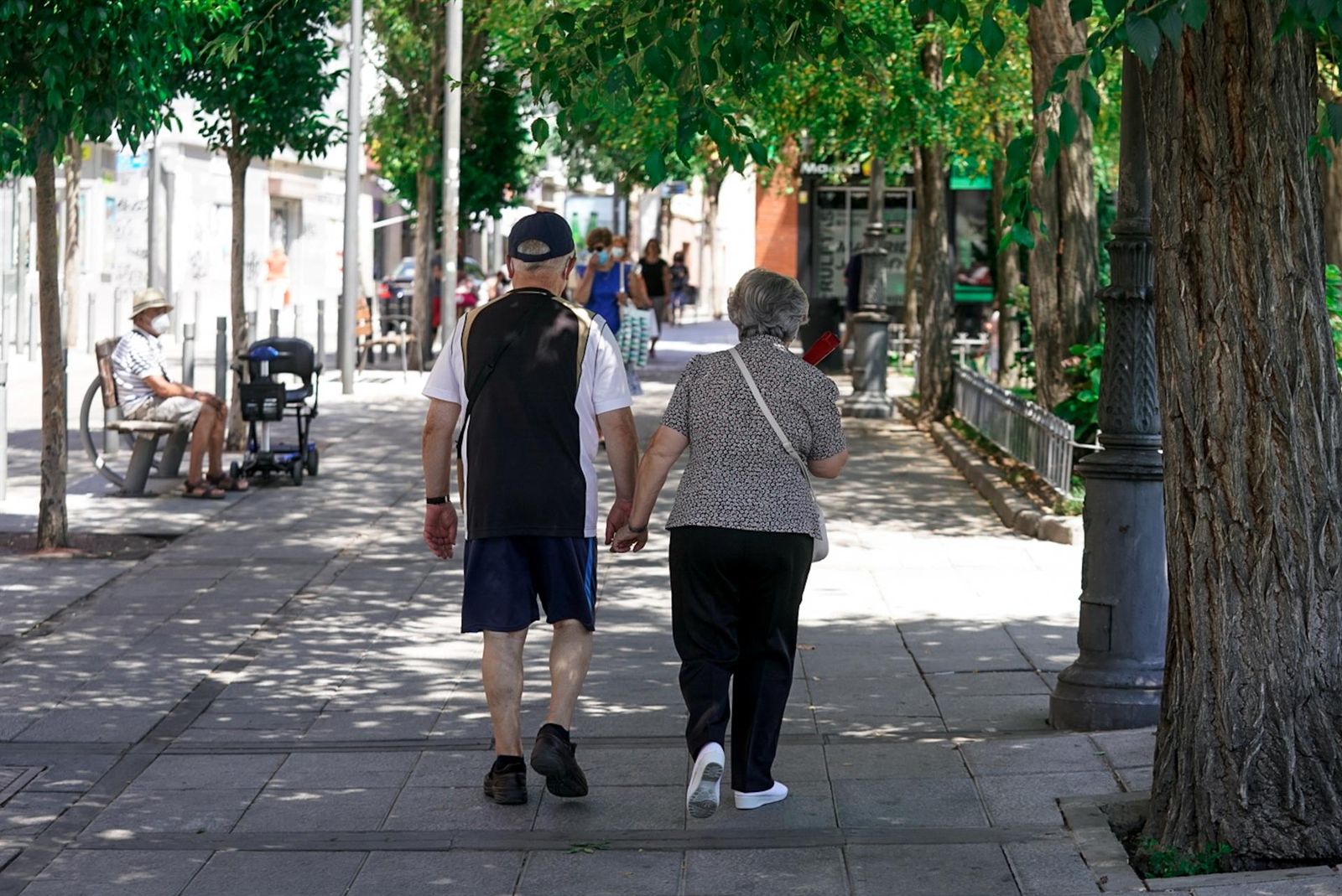 Una pareja de jubilados paseando por la calle- Archivo