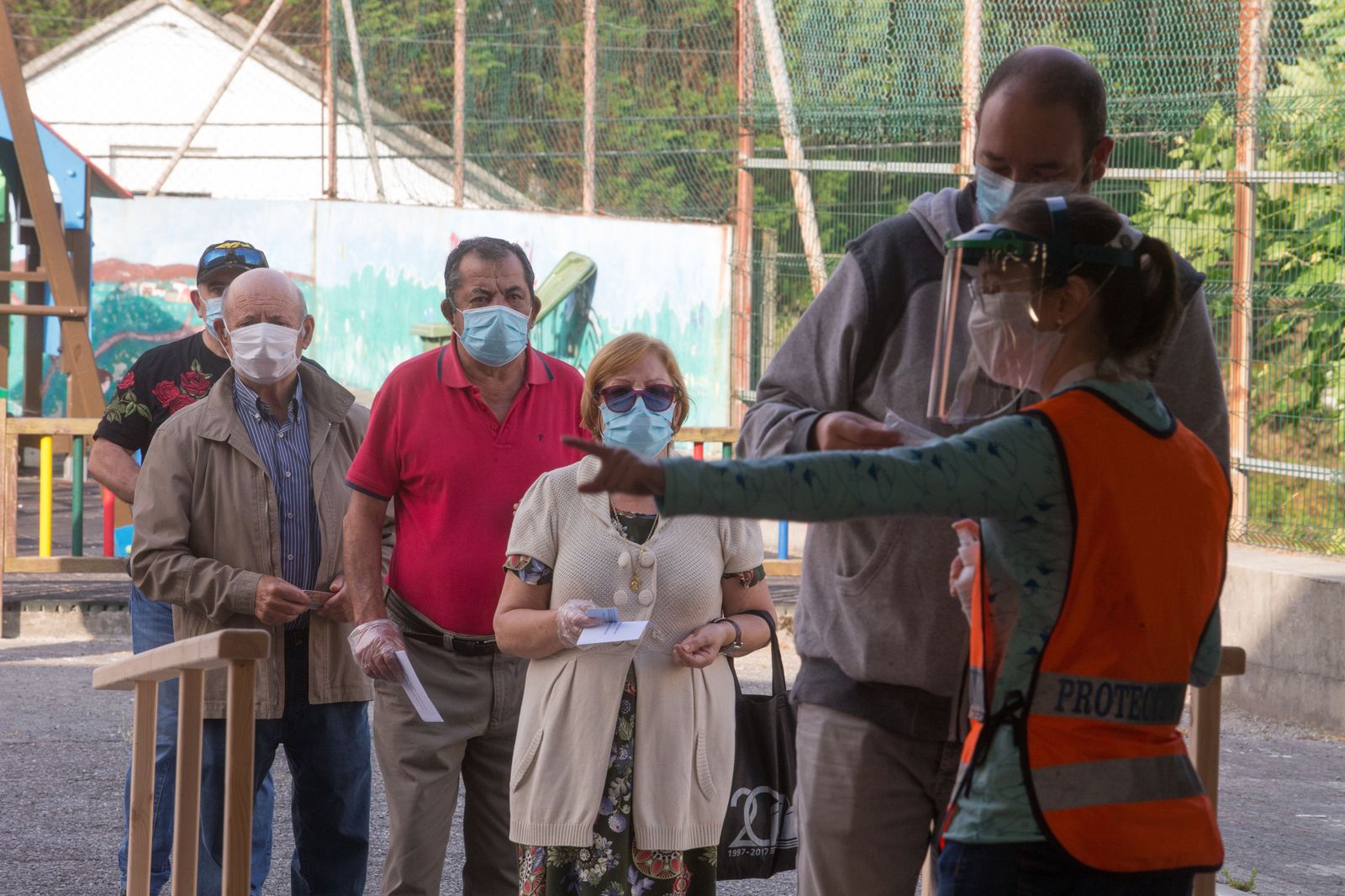 Varias personas protegidas con mascarillas hacen cola para poder votar en las elecciones autonómicas de Galicia