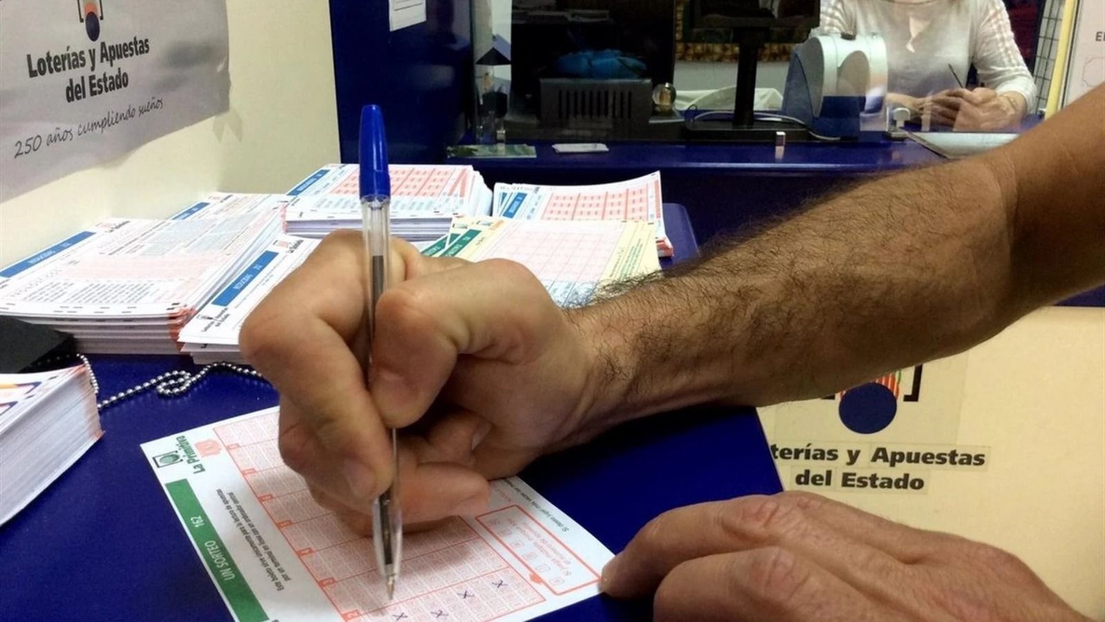 Un hombre rellena un boleto de la Bonoloto. EP Un hombre rellena un boleto de la Bonoloto. EP