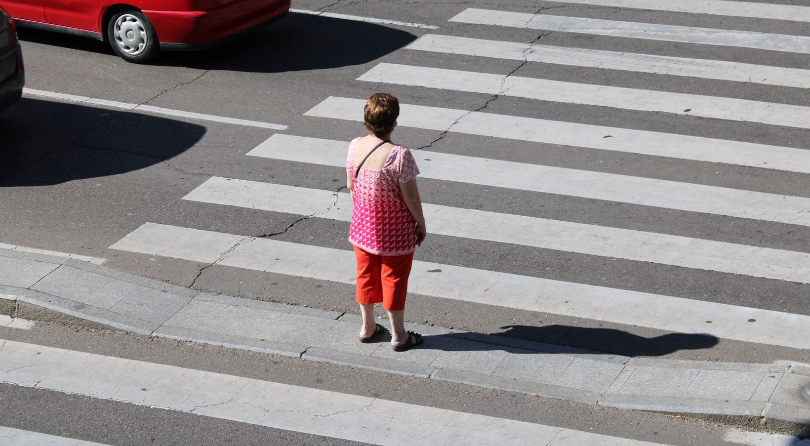 Una mujer espera en un paso de peatones en una calle de Salamanca
