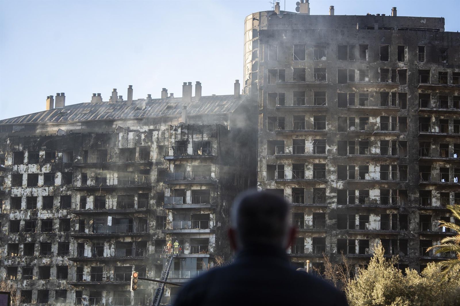 Un hombre observa la estructura del edificio tras el incendio de ayer, 22 de febrero, en el barrio de Campanar, a 23 de febrero de 2024, en Valencia, Comunidad Valenciana (España).   Jorge Gil   Europa Press
