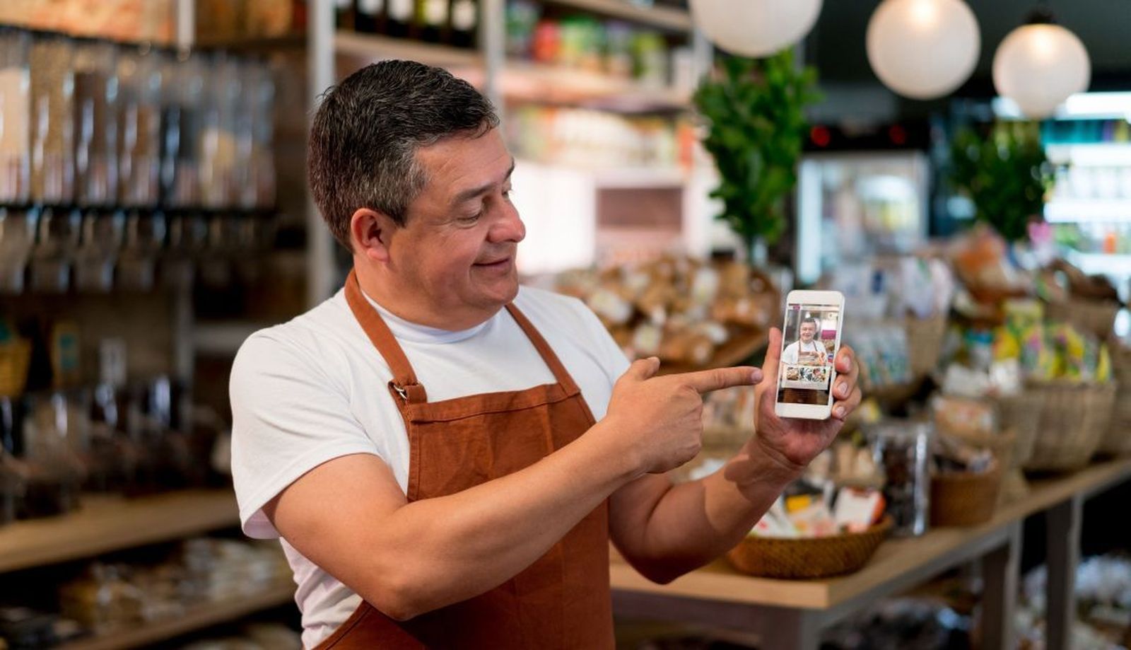 El dueño de una pyme de alimentación muestra en su smartphone un sistema para vender online sus productos. Archivo El dueño de una pyme de alimentación muestra en su smartphone un sistema para vender online sus productos. Archivo