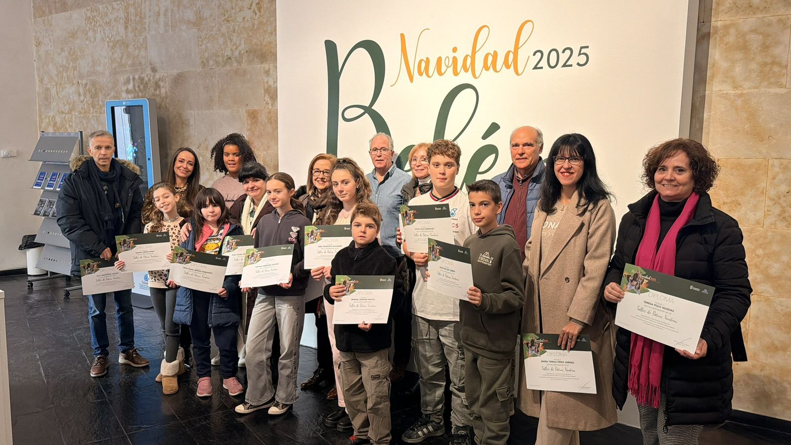 La concejala de Tradiciones, Carmen Seguín, entrega los diplomas a los participantes en los talleres de belenes navideños