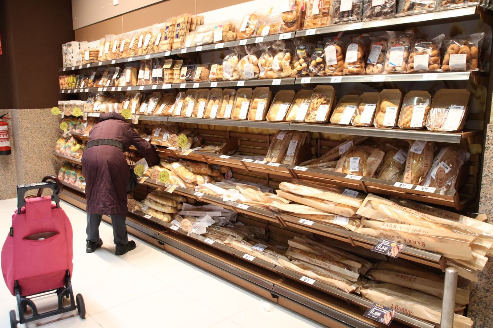 Una mujer compra pan en un supermercado