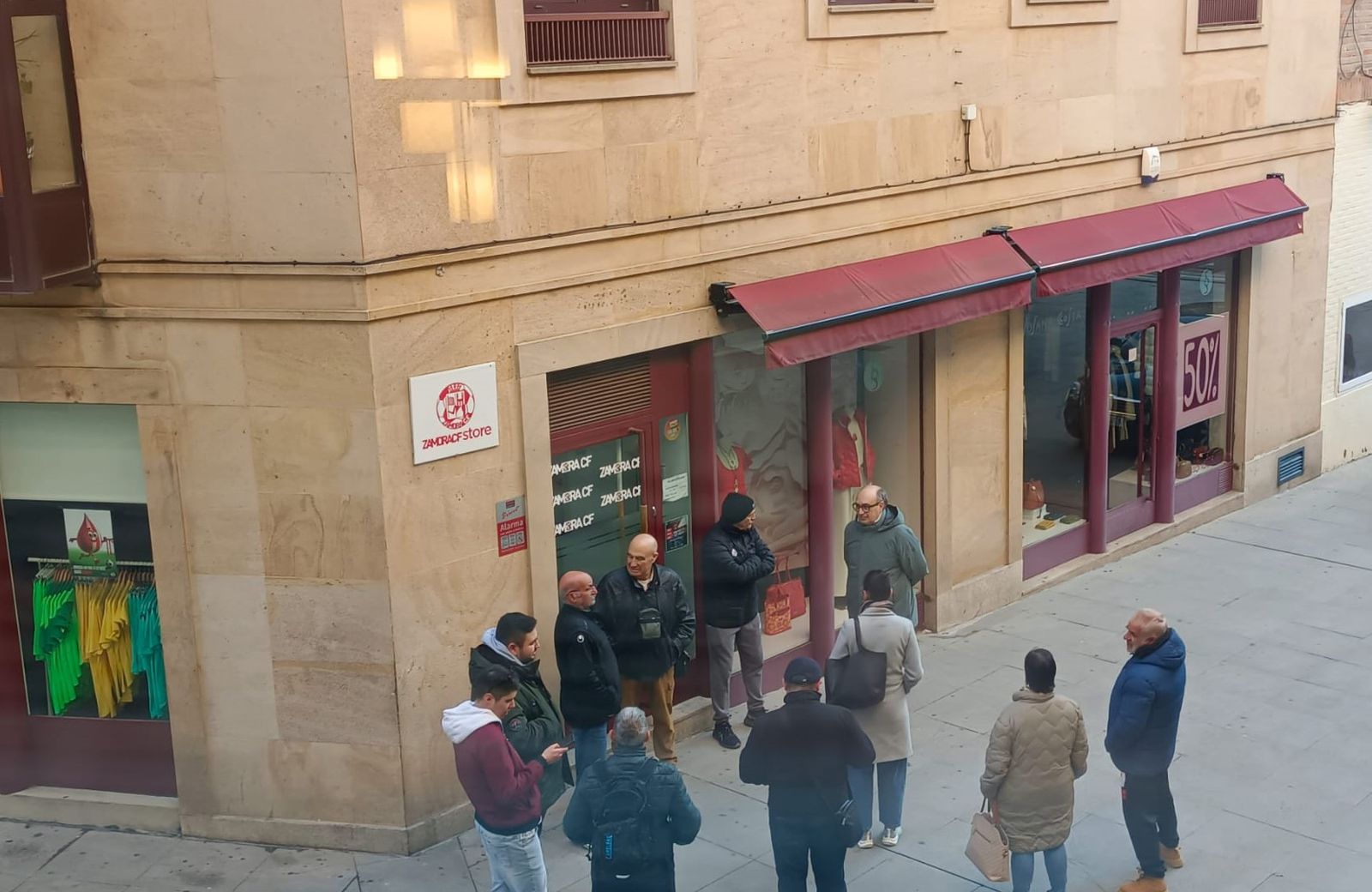Aficionados rojiblancos a la espera de que abra la tienda del Zamora C.F