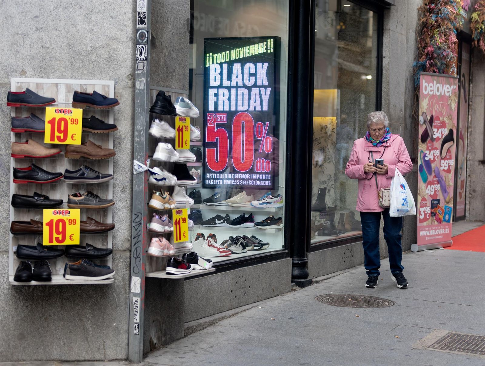 Una mujer pasa por delante de una tienda que anuncia un cartel publicitario del ‘Black Friday’,  Eduardo Parra - Europa Press