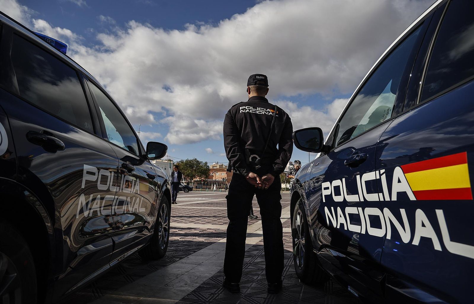 Archivo - Un ugente de la Policía Nacional entre dos coches - Rober Solsona - Europa Press - Archivo