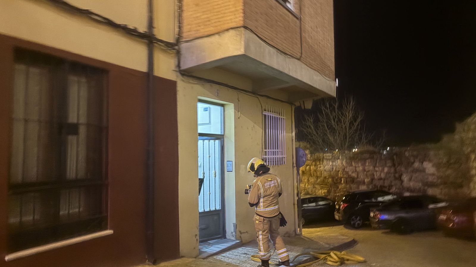 Uno de los bomberos desplazados a la puerta de la vivienda