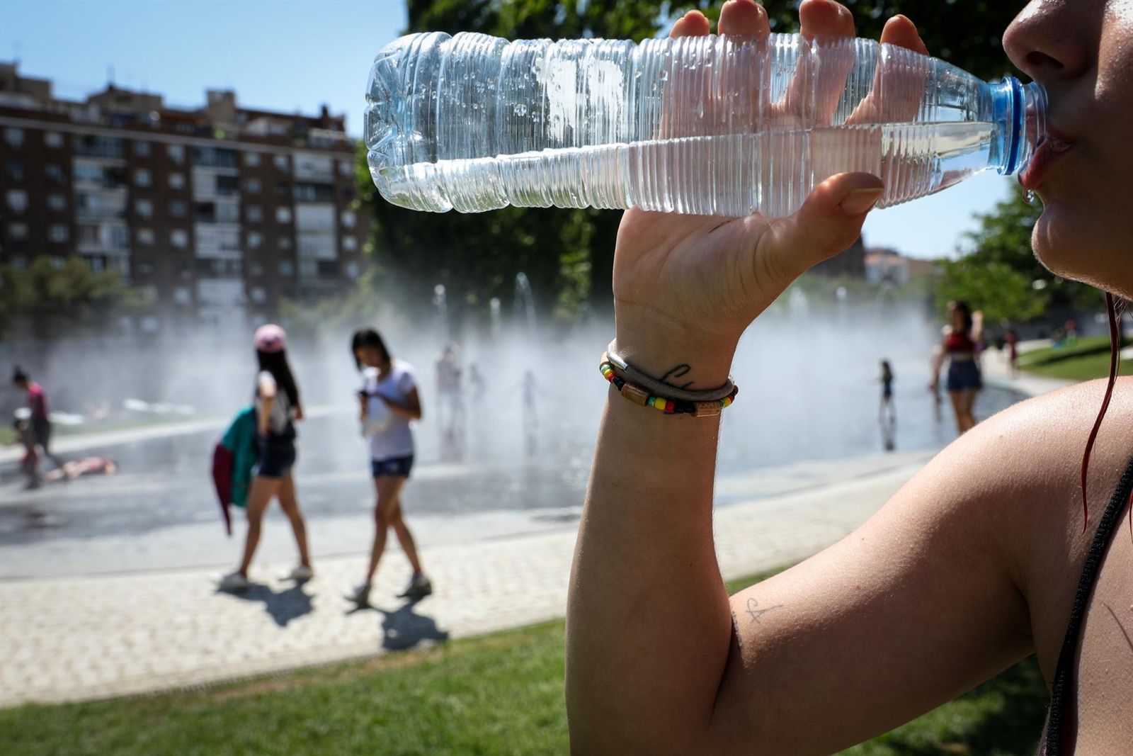 Una mujer bebe agua de botella para refrescarse durante una ola de calor. EP