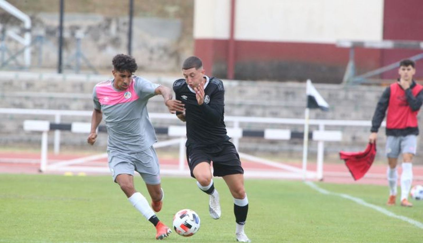 De fondo, un jugador con un peto hace de asistente