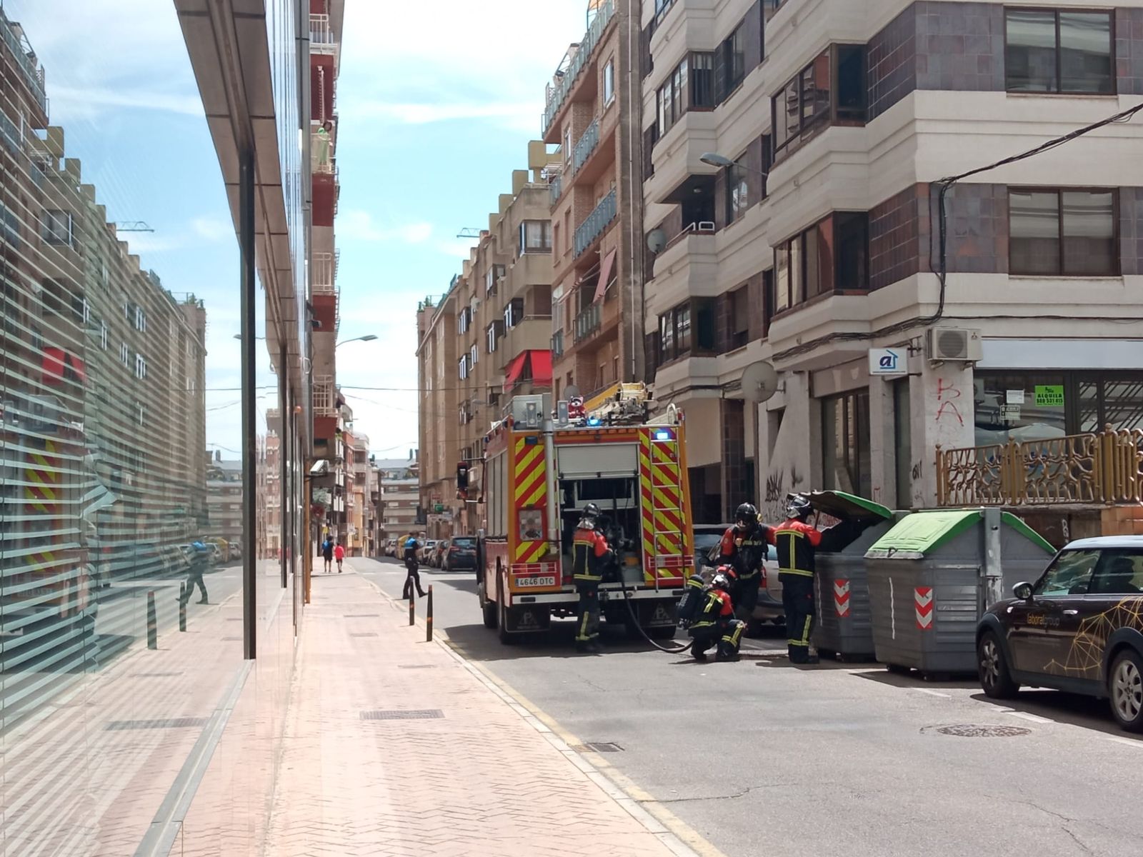 Bomberos refrescando el contenedor para evitar la propagación del incendio.