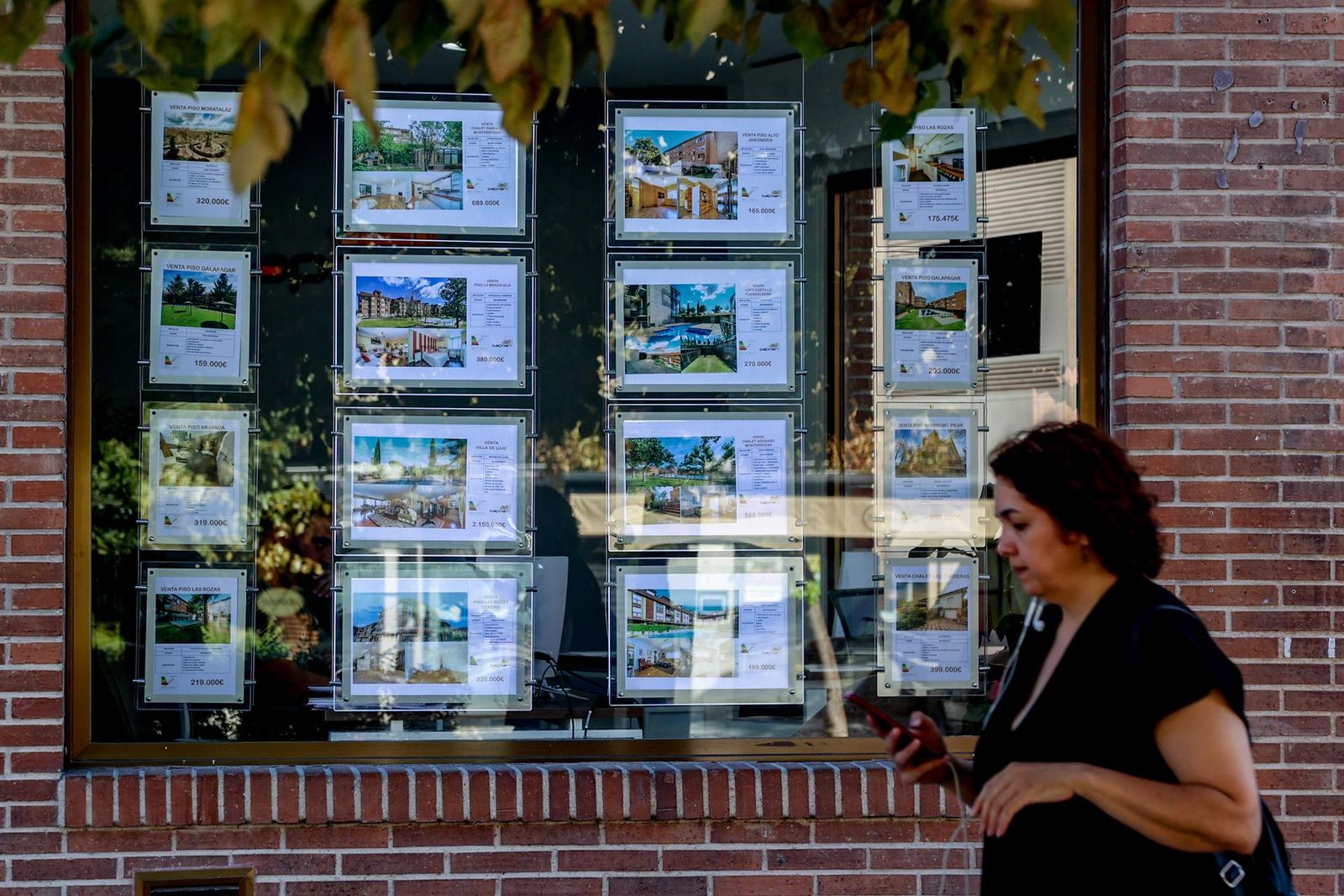 Una mujer camina frente a un escaparate de anuncios de viviendas.   Ricardo Rubio   Europa Press   Archivo