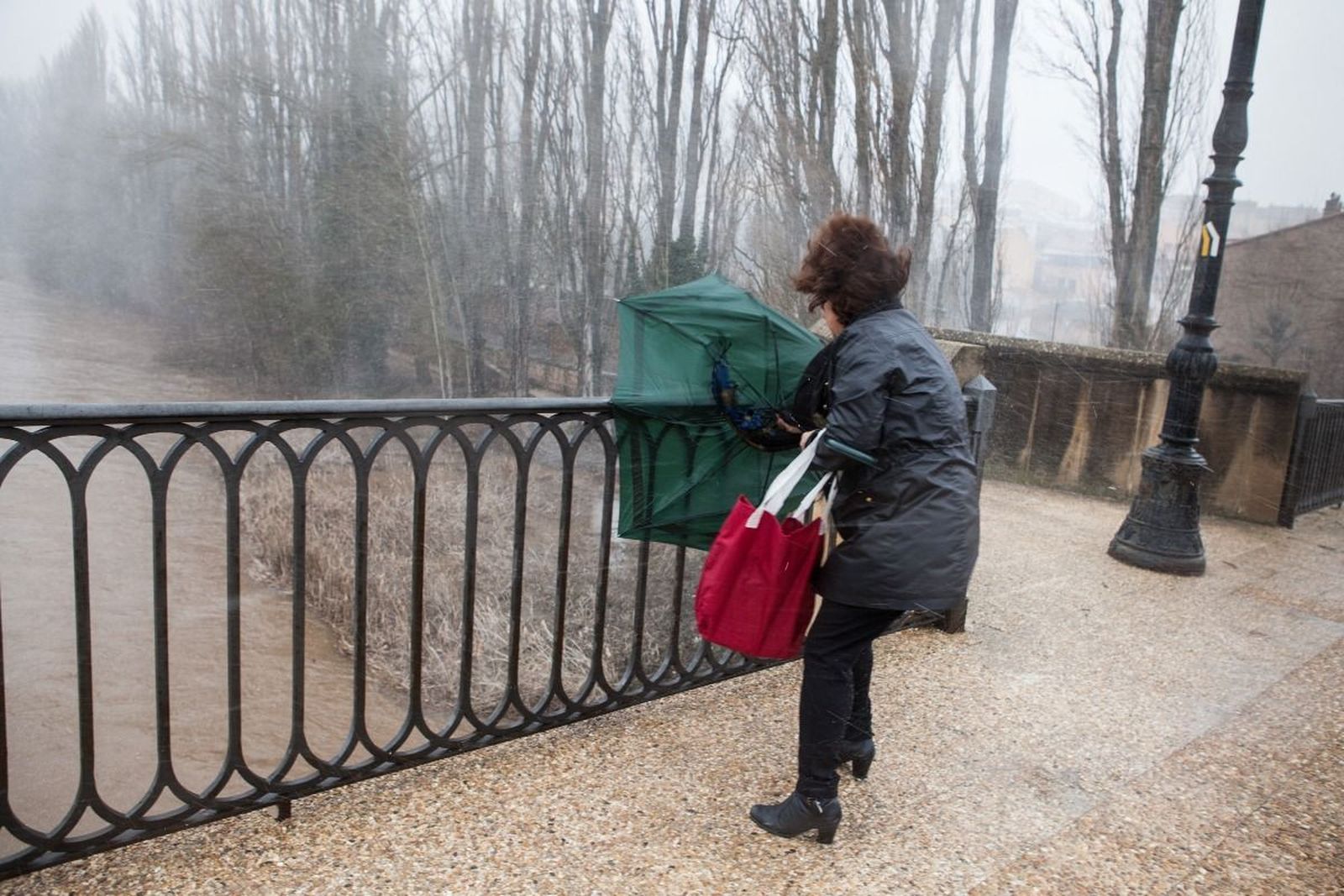 Mujer con un paraguas roto por el viento. Archivo.