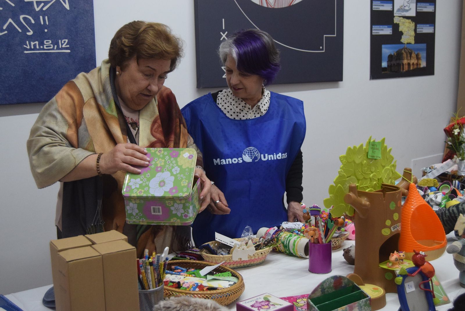 Una mujer compra un artículo. Rastrillo solidario Manos Unidas