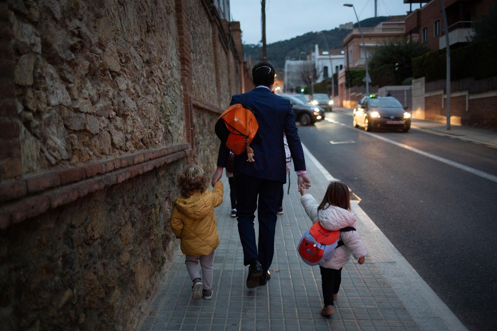 Imagen de archivo   Dos niñas de la mano con un hombre yendo al colegio