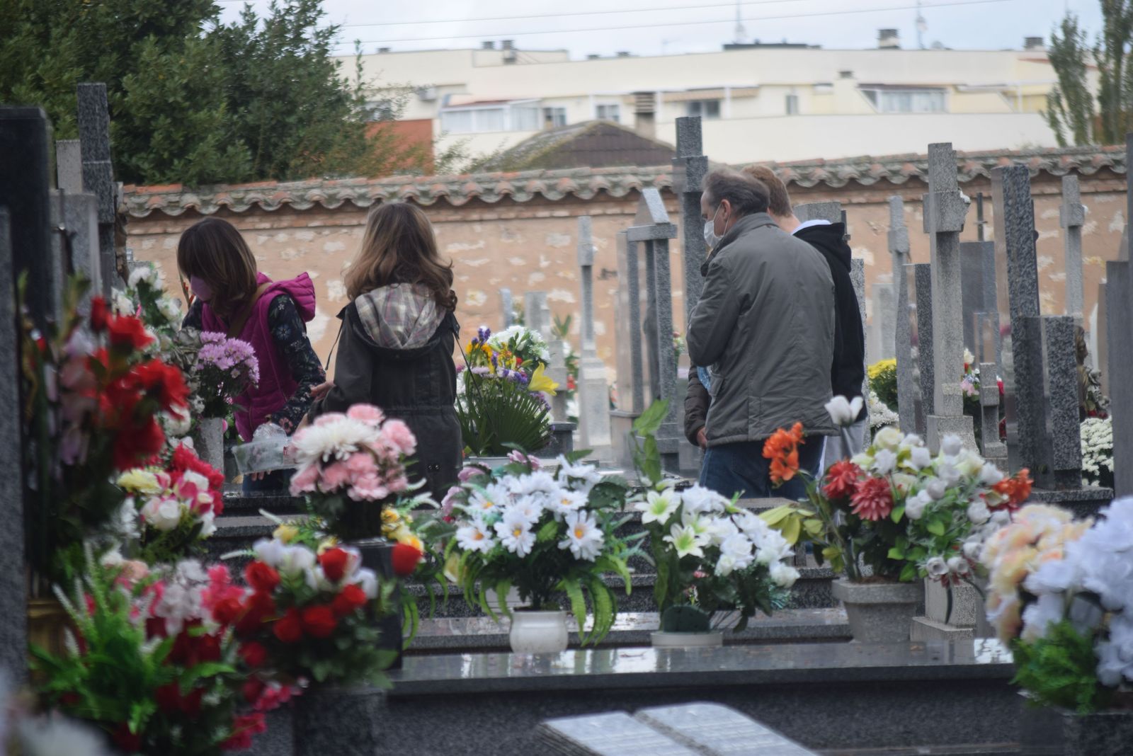 Varios zamoranos depositan flores en una tumba