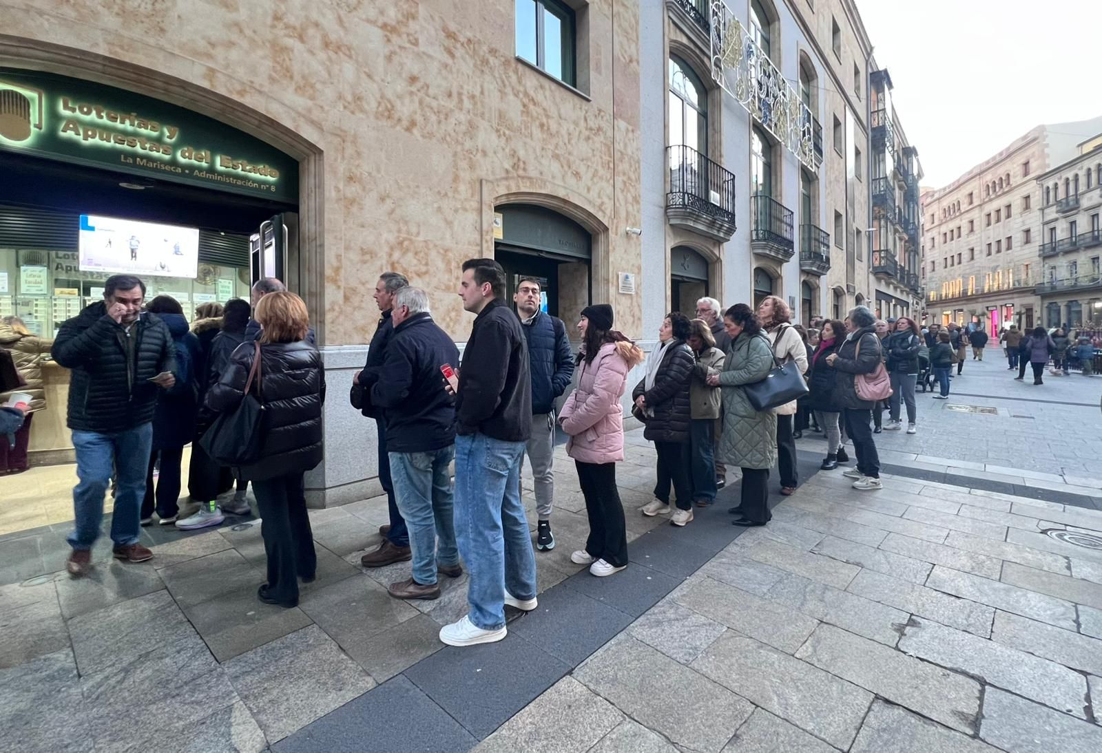 Largas colas en Salamanca por la ilusión ilusión navideña del número de la Lotería de la USAL