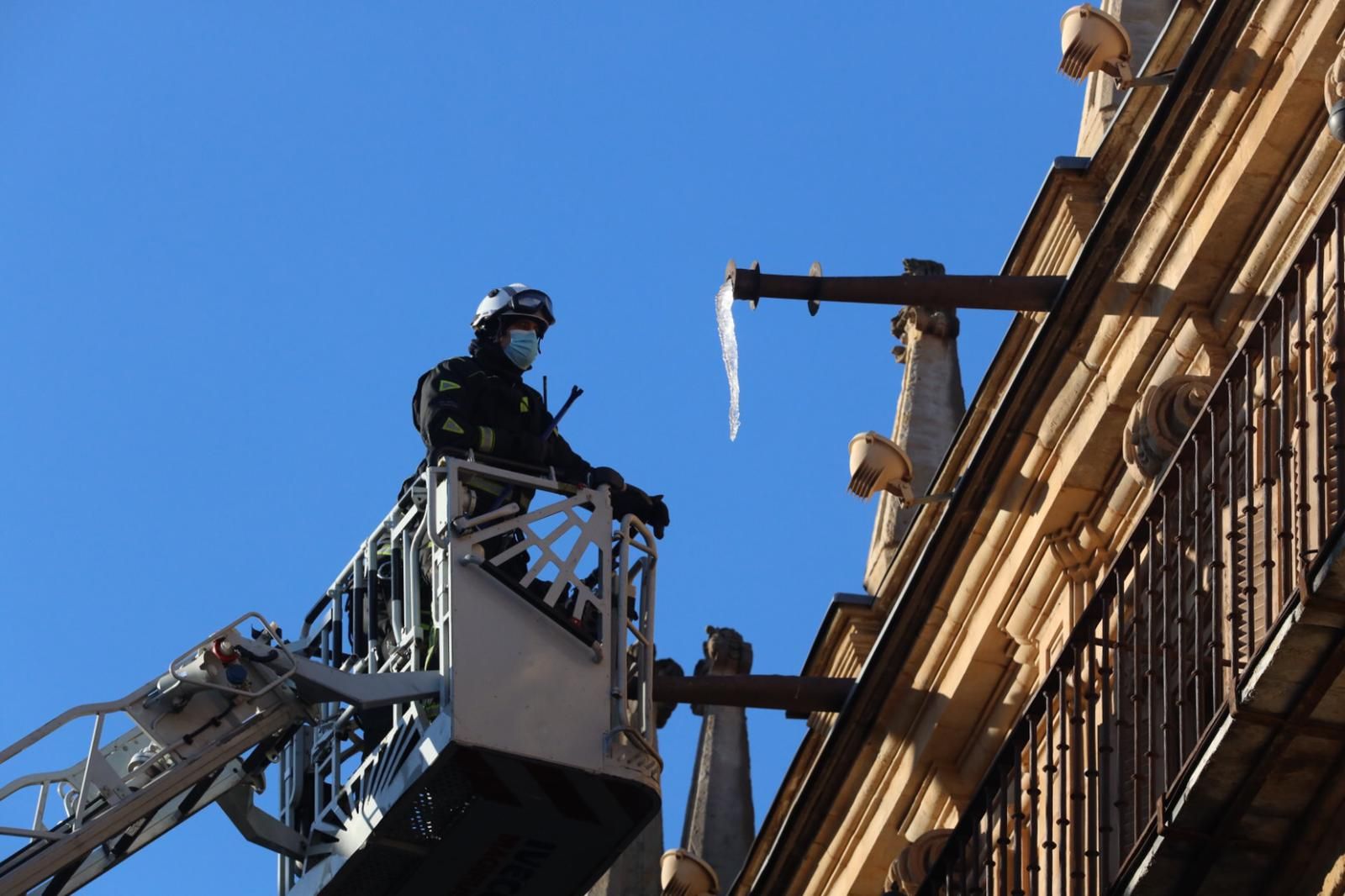 Los bomberos retiran peligrosos carámbanos de hielo que amenazaban con caer de la cubierta de la Plaza Mayor