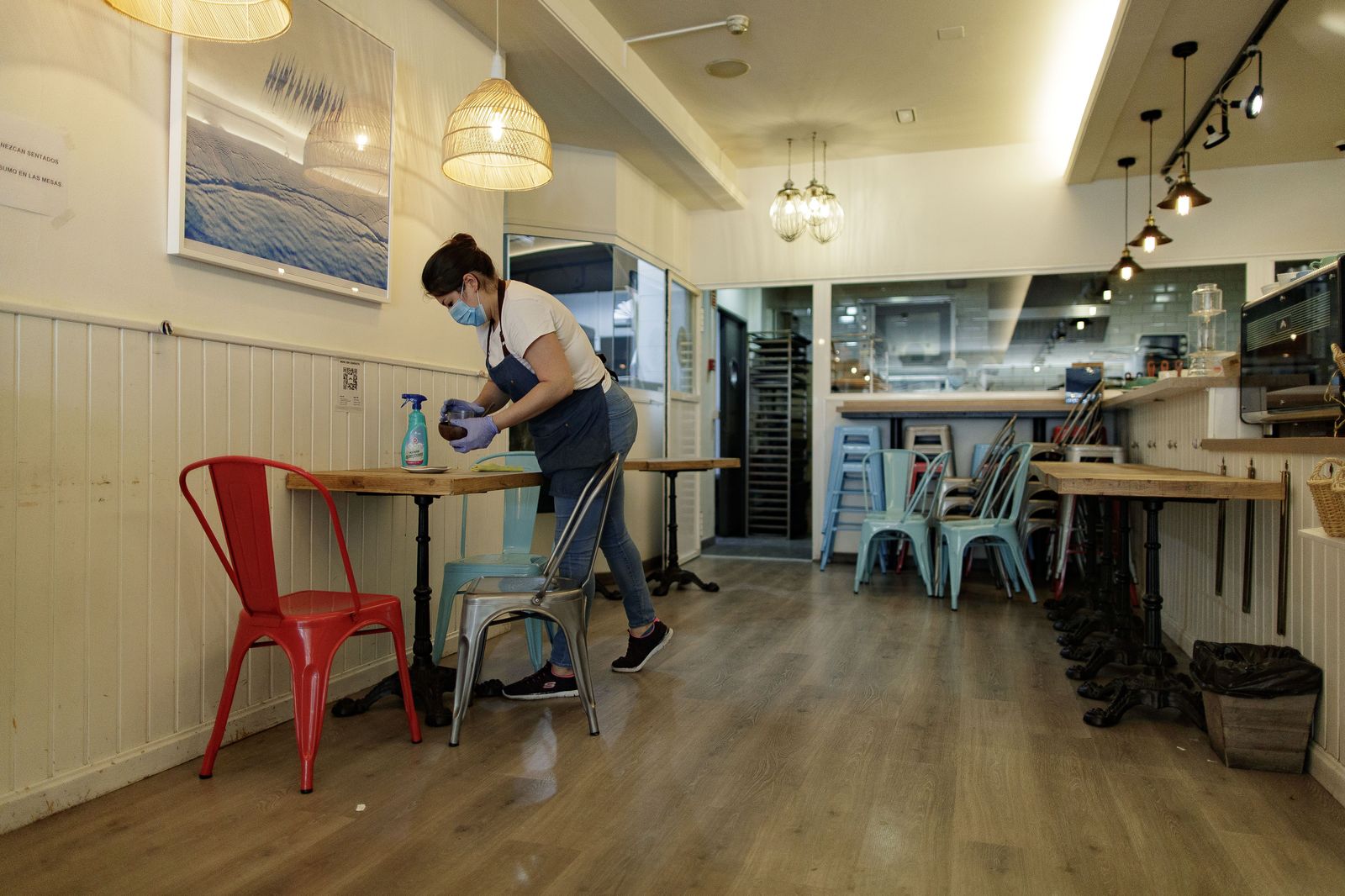 Una camarera limpiando una mesa en un local