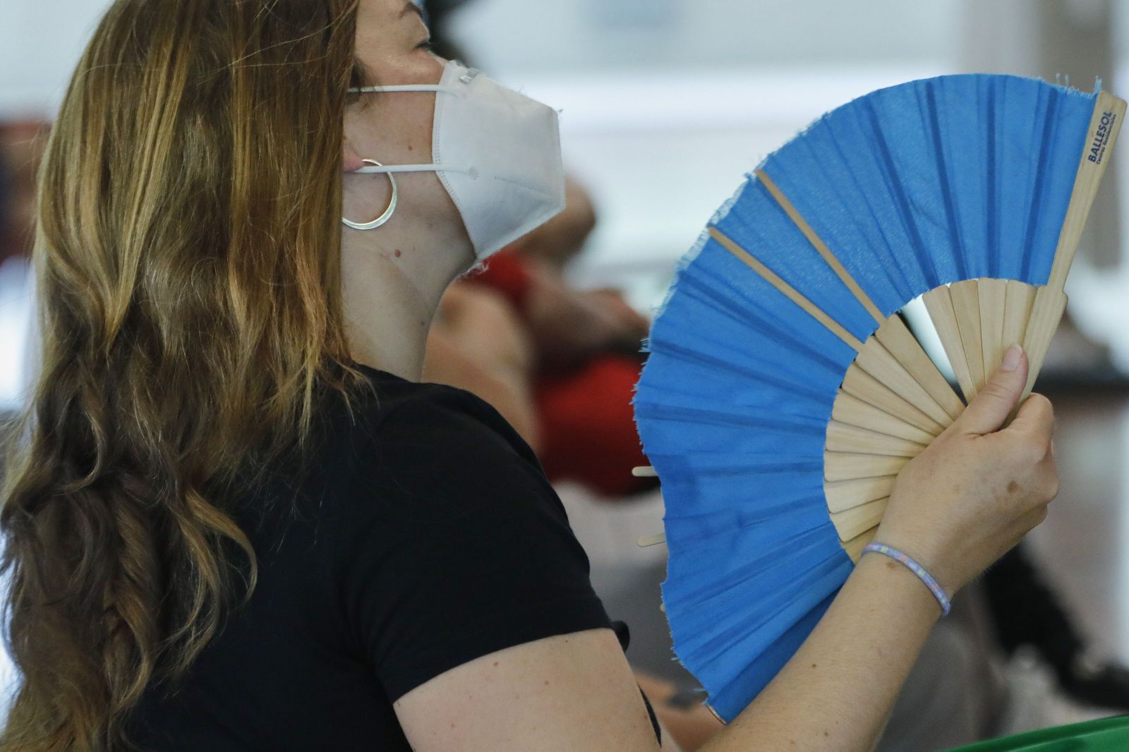 Una mujer con mascarilla se abanica en Madrid (España), a 29 de junio de 2020. El calor pone desde este lunes en aviso a una quincena de provincias de Andalucía, Castilla y León, Castilla-La Mancha