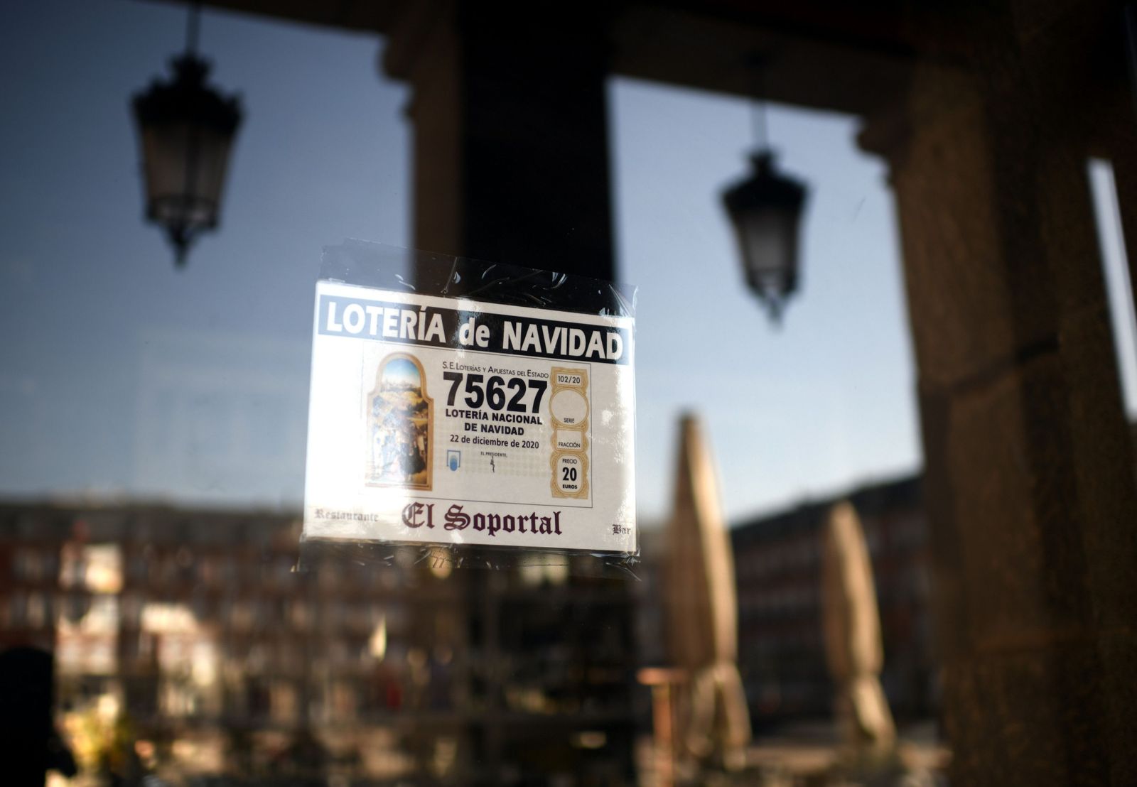 Décimo del Sorteo Extraordinario de la Lotería de Navidad 2020 pegado en el escaparate de un restaurante de la Plaza Mayor, en Madrid, España, a 10 de noviembre de 2020. Debido a las medidas de lim Décimo del Sorteo Extraordinario de la Lotería de Navidad 2020 pegado en el escaparate de un restaurante de la Plaza Mayor, en Madrid, España, a 10 de noviembre de 2020. Debido a las medidas de lim