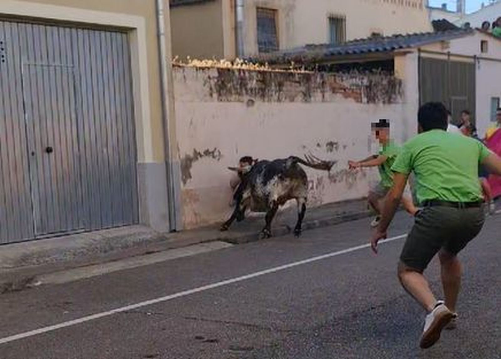 Un novillo golpea a un joven contra una pared y lo deja inconsciente en las fiestas del Barrio Nuevo de Ciudad Rodrigo. Captura de la imagen del vídeo cedido por Bazar Glamour Doble S