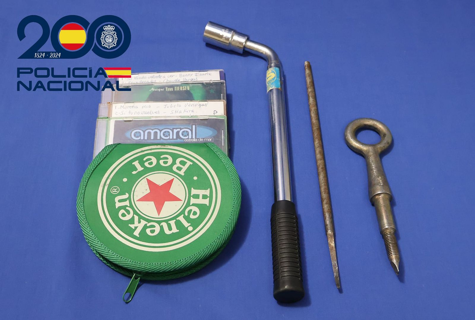 Llave de hierro y CDs encontrados entre las pertenencias del hombre detenido por robar en seis vehículos aparcados en el Camino de las Aguas. Foto Policía Nacional