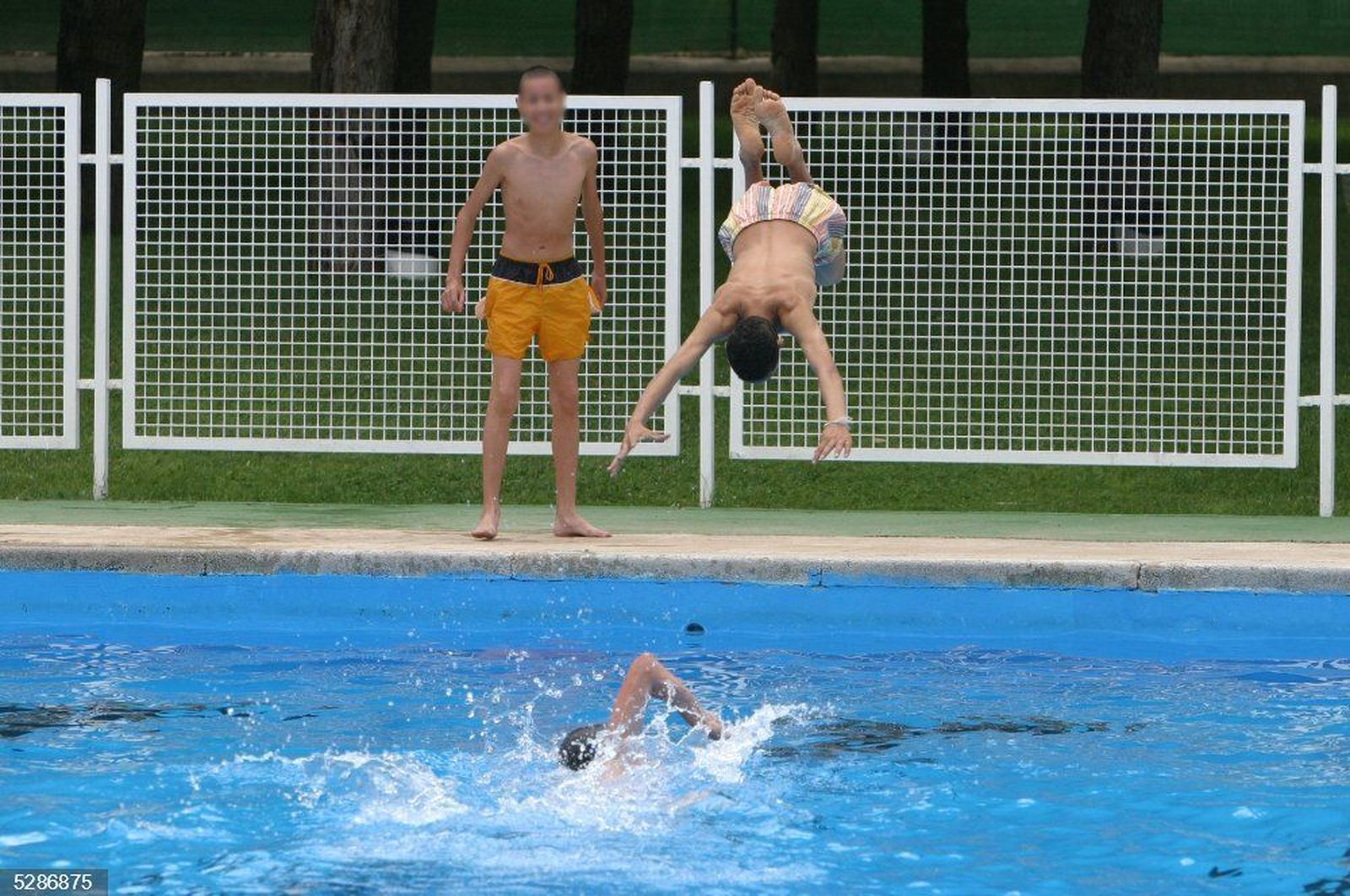 Joven realiza una zambullida en una piscina Joven realiza una zambullida en una piscina