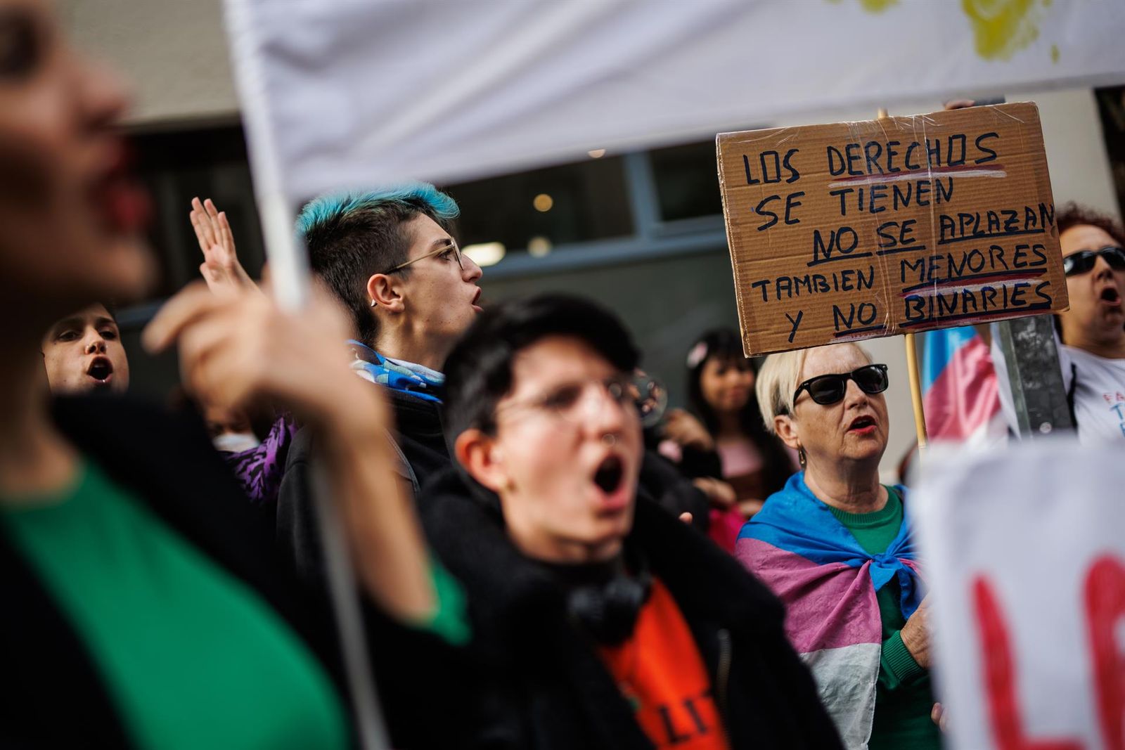 Una mujer con una bandera trans sujeta un cartel en el que se lee: 'Los derechos se tienen no se aplazan'. FOTO EP