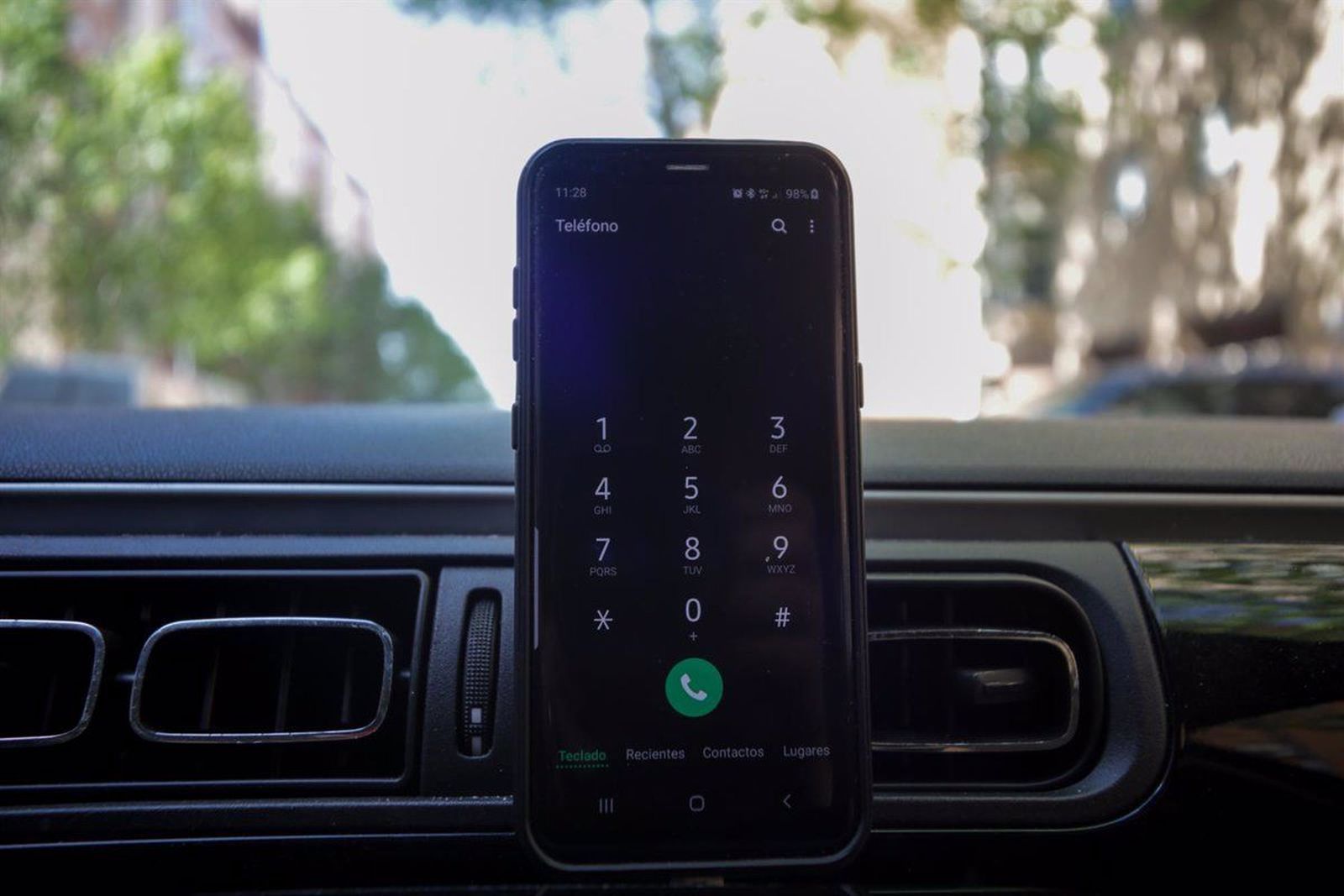 Un teléfono móvil, en un soporte en el salpicadero