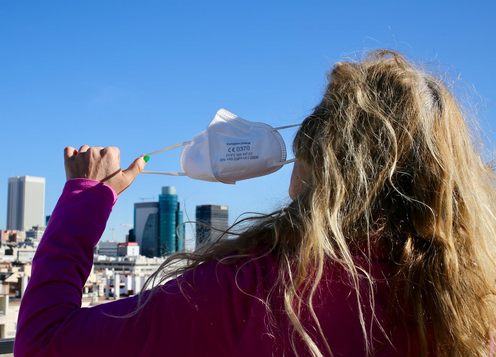 Una mujer se quita la mascarilla EP