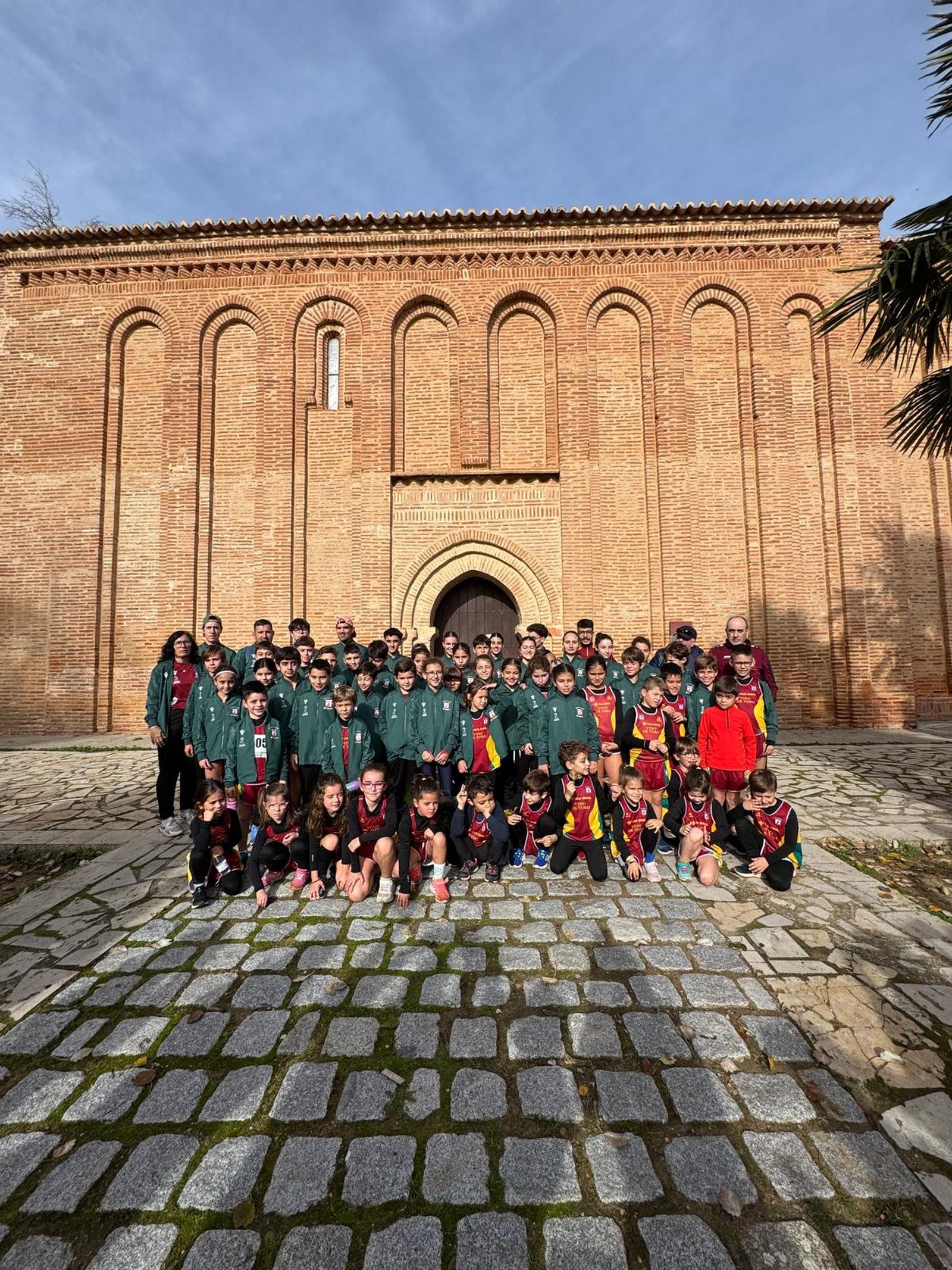 integrantes de la escuela de atletismo del vino toro caja rural con sus monitores