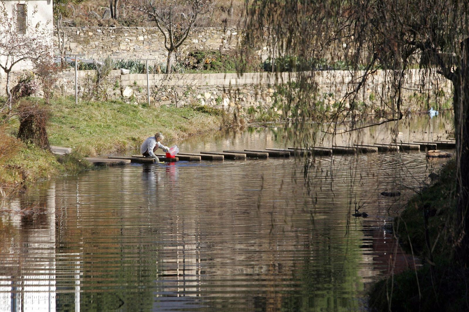 Leticia Pérez / ICAL . Una vecina de Rihonor de Castilla (Zamora) lava la ropa en el río de Onor