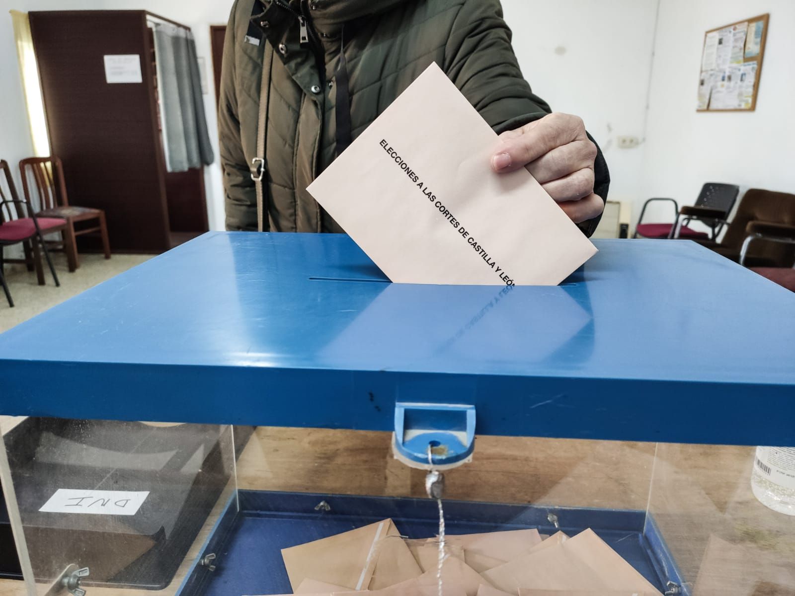 Una mujer deposita su voto en una mesa electoral