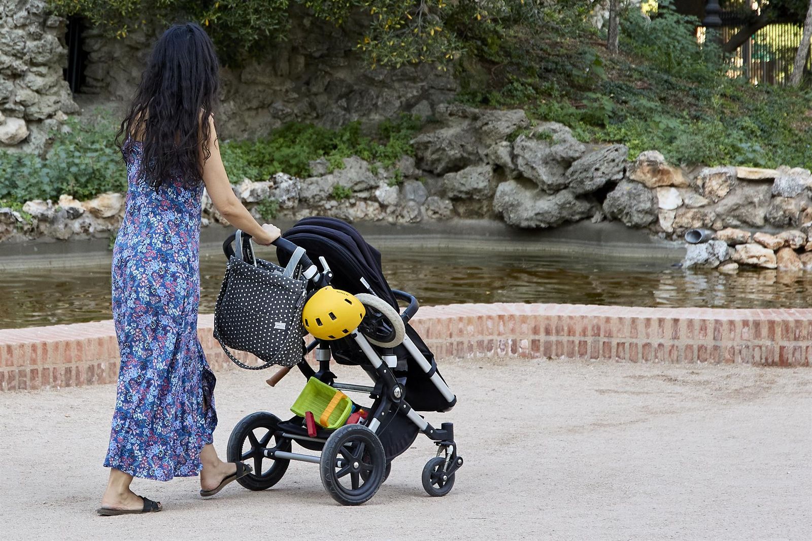 Una mujer pasea con un carrito de bebé en el parque de El Retiro. - Jesús Hellín - Europa Press - Archivo