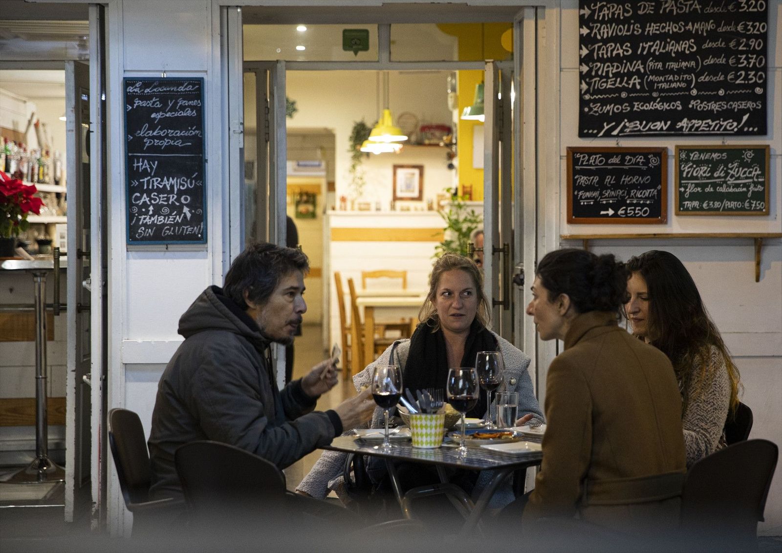 Varias personas en la terraza de un bar tras la apertura de bares y restaurantes en Sevilla